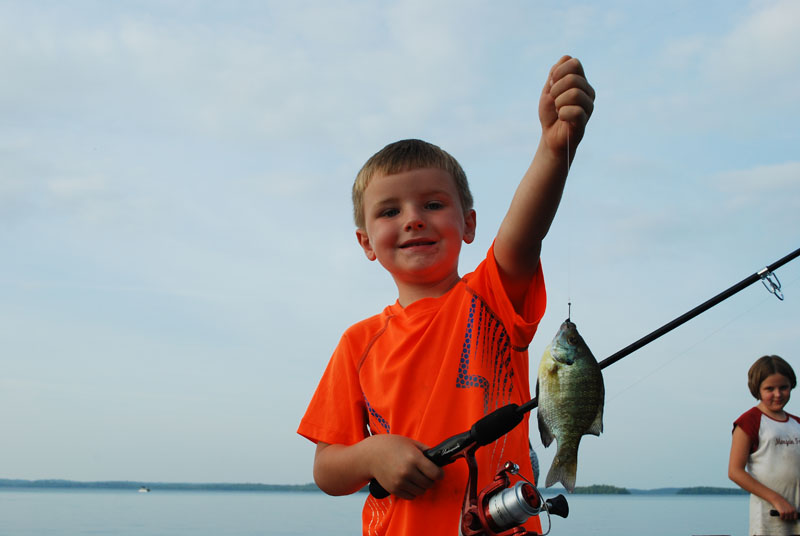 kid fishing for sunfish on dock