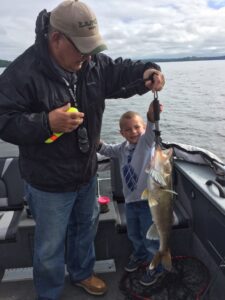 man and child holding fish